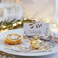 a white plate topped with pastries on top of a table next to a christmas tree