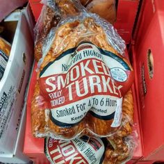 a pile of smoked turkey wrapped in plastic and sitting on top of a red bin