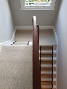 a staircase with carpeted steps leading up to a window