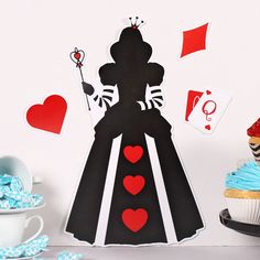 a cupcake with blue frosting and red hearts on it next to a paper cutout