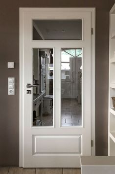 a white door in a room with shelves on either side