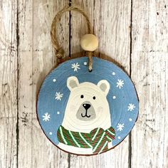 This hand painted Blue Polar Bear Christmas ornament is the perfect addition to your Christmas Tree. The ornament was painted using acrylic paint on wood slices. The ornament is adorned with a wooden bead. The ornament you receive may vary slightly from the photo, as each one is individually painted and wood slices vary in shape. (100% hand painted, no stamping or vinyl) -Approx. 3 inch rustic wood slice ornament with a wooden bead -Approx. .25 inch deep -Poly coat -Twine hanger attached for easy hanging -Blank backside -Indoor use is optimal All monitors are slightly different so the colors appearing on your screen may be slightly different. All photos and illustrations are copyright to Ruth Miller Creative. Happily made in Kansas City! Hometown Ornaments, Christmas Ornament Painting Ideas Easy, Ornaments Painting, Wood Ornaments Painted, Flat Ornament Ideas, Painted Wood Discs Christmas Ornament, Painting Wood Ornaments, Wood Ornament Painting, Christmas Ornament Art