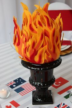 there is a cake that looks like a fireball on top of a table with flags in the background