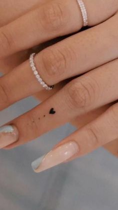 two hands with manicured nails and rings on them, one has a diamond ring