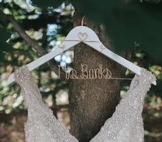 a wedding dress hanging on a tree with the word free banks written in cursive letters