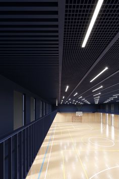 an empty basketball court with lights on the ceiling