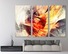 three abstract paintings hanging on the wall in a living room