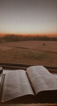 an open book sitting on top of a window sill