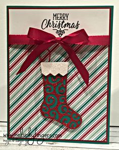 a christmas card with a stocking hanging from the front and red ribbon on top