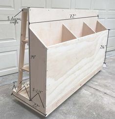 an unfinished storage box with measurements for the top and bottom section, sitting in front of a garage door