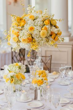 the centerpieces are filled with yellow and white flowers