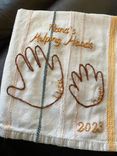 a towel with embroidered hands on it