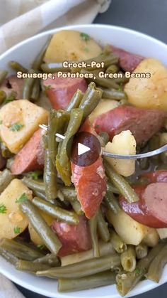 a white bowl filled with green beans, potatoes and ham