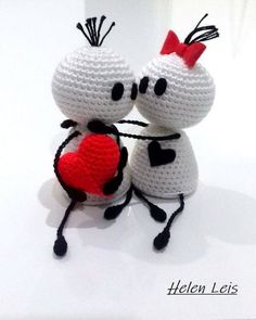 two crocheted white and black cats with red heart on their backs, sitting next to each other