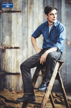 a man sitting on top of a wooden chair