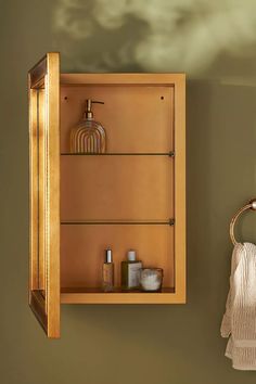 a bathroom with a wooden cabinet and towel rack on the wall next to a mirror