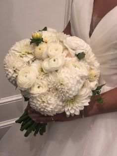 a bride holding a bouquet of white flowers