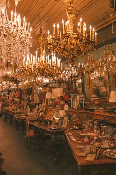 a room filled with lots of tables covered in fancy chandeliers and pictures on the walls