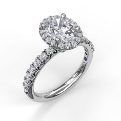 a white gold engagement ring with an oval shaped diamond center and pave set shoulders