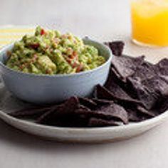 a bowl of guacamole and tortilla chips on a plate