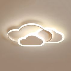 two white clouds are lit up on the ceiling in this minimalistic light - filled room