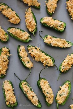 several green peppers with cheese on them sitting on a baking sheet, ready to be cooked