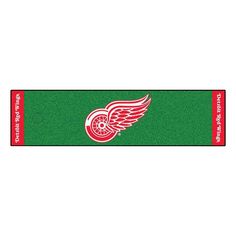 the detroit red wings logo is shown on a green mat with red trimmings