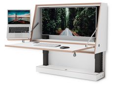 a computer desk with a laptop on it and a monitor attached to the back wall