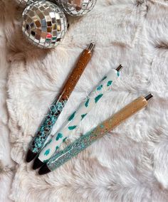 three pens sitting on top of a white fur covered floor next to disco ball ornaments