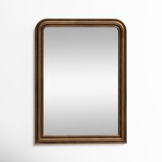 a mirror hanging on the wall next to a sink in a room with white walls