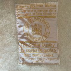 a white and gold label on the back of a jacket that says, bay point blanket couverture a marque de la baule d hudson