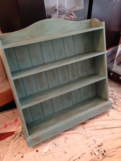 an old blue bookcase sitting on top of a table