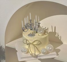 there is a cake with many candles on it and pearls around the top, as well as other decorations