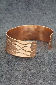 This copper bracelet was made by Navajo silversmith Elaine Tahe. The inside of the cuff is stamped TAHE and copper.Size: 5 3/4" (will fit up to a 6 3/4" wrist)Gap: 1"Width: 3/4Free shipping on all orders! We ship with USPS and always include tracking. All orders ship within a day of payment.Returns are accepted up to 30 days after you receive your order. Just send us a message. Our shop offers cash back or store credit. The item must be returned in new condition. Adjustable Etched Copper Jewelry, Adjustable Copper Artisan Cuff Bracelet, Engraved Copper Bracelet Jewelry, Engraved Copper Bracelet, Artistic Copper Cuff Bracelet, Unique Copper Cuff Bracelet With Patina, 100% Copper Braclet, Artisan Silver-colored Copper Cuff Bracelet, Bear Carving