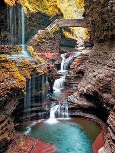 there is a waterfall in the middle of some rocks with water running down it's sides