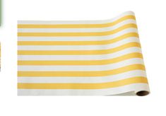 a yellow and white striped table cloth next to a roll of paper with markers on it