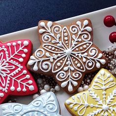 four decorated cookies sitting on top of a white plate