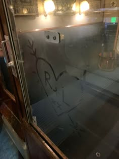 the reflection of a person in a glass door with graffiti on it's side