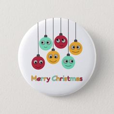 a button with christmas balls hanging from it's strings and the words merry christmas