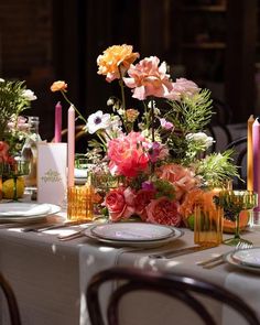 the table is set with flowers and candles