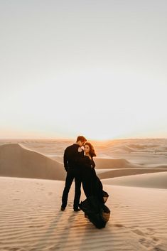 a man and woman standing in the desert