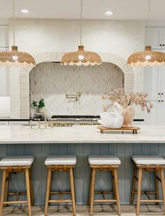 a kitchen with three stools and an island