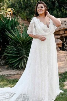 a woman in a white dress posing for the camera with her hand on her hip