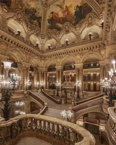 an ornate building with many chandeliers and paintings on the ceiling, along with marble staircases