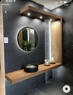 a bathroom with a mirror, sink and shelf on the wall next to a plant