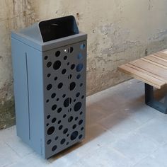 a trash can sitting next to a wooden bench