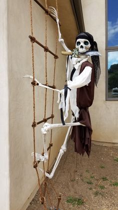 a skeleton hanging from the side of a building with chains attached to it's sides