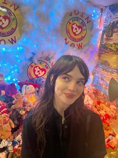 a woman standing in front of a bunch of stuffed animals