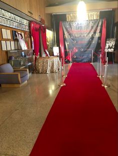 a red carpet is on the floor in front of a stage with chairs and tables