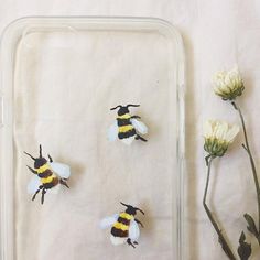 three bees sitting on top of a piece of paper next to flowers